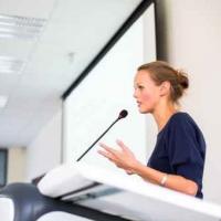 Woman at a podium giving a presentation