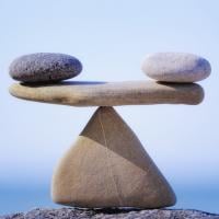 Two rocks balancing on another rock acting as a fulcrum