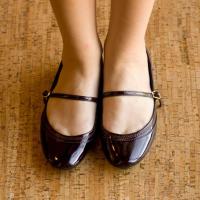 Woman's feet standing on a wood floor