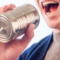 Businessperson talking into a tin can