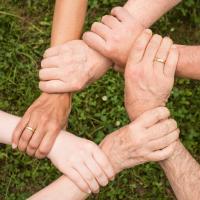 Testing team interlocking their hands in support