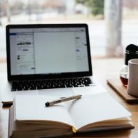 An open notebook in front of a computer