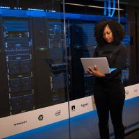 Engineer standing next to rows of database servers