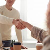 Developer and tester smiling and shaking hands