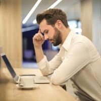 Developer looking at his laptop and trying to solve a problem