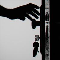 Silhouette of person unlocking a door with keys