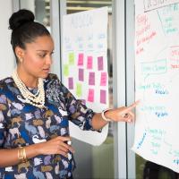 Agile team member pointing at user stories written on sticky notes