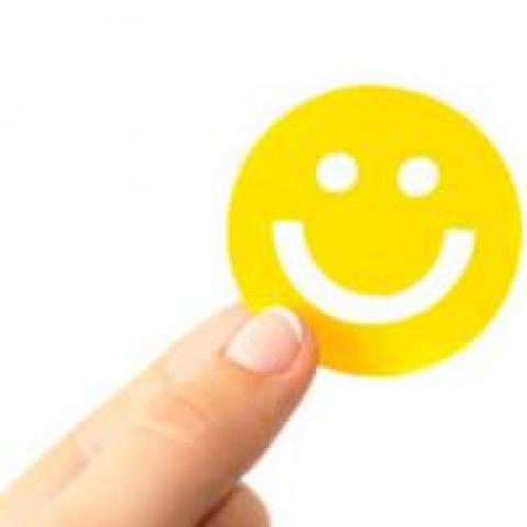 Hand holding happy face sticker