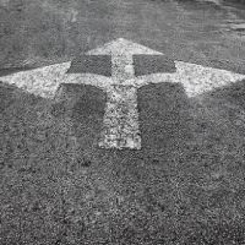 Asphalt with painted arrows pointing in three directions
