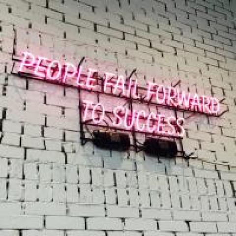 Neon sign saying "People fail forward to success"