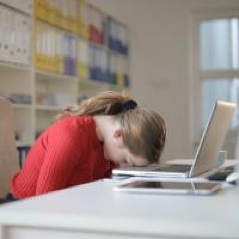 Woman putting her head down on her laptop in frustration