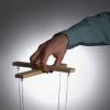 A hand controlling a marionette