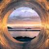 Sunset over the sea seen from the inside of a large pipe, photo by Erlend Ekseth