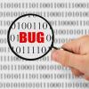 A magnifying glass showing the word "bug" among code