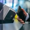 A person tapping their phone to a digital payment system, photo by Jonas Leupe