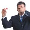 Man covering his eyes while throwing a dart