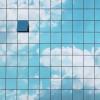 Building with clouds reflected on the side