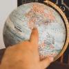 Person pointing at a globe